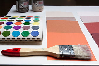 Paintbrush and Color Swatches on White Table