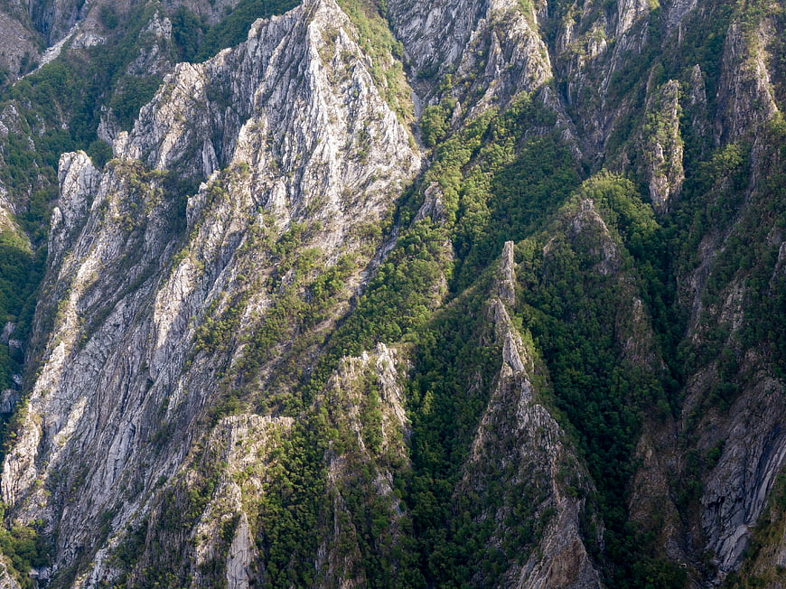 Aerial View of Rugged Mountain Peaks with Dense Forest