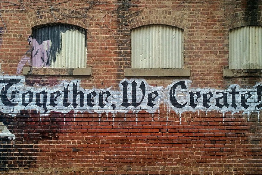 Together We Create Graffiti on Weathered Brick Wall
