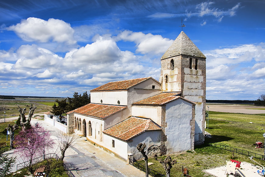 Historic stone church with bell tower in rural landscape