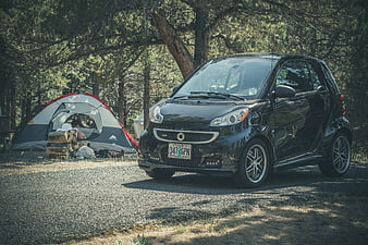 Black Smart Car Parked at Forest Campsite
