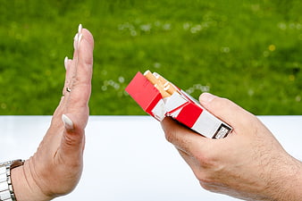 Woman's hand refusing a pack of cigarettes from a man