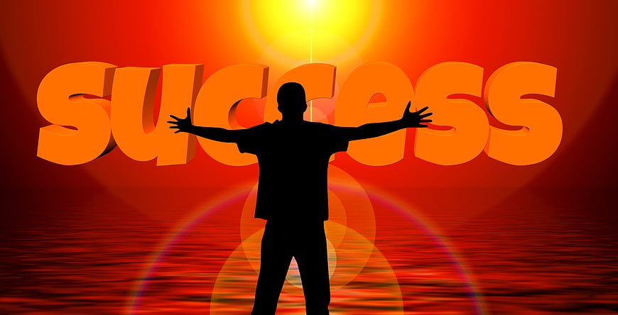 Silhouette of person with arms raised against success text background