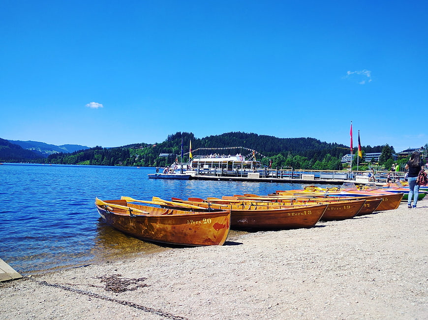 Wooden rowboats on a sunny lake beach with mountains