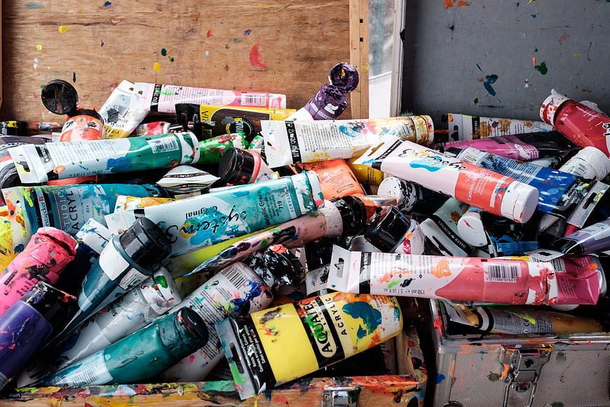 Pile of used multicolored acrylic paint tubes in artist studio