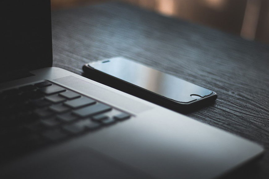 Laptop and Smartphone on Dark Wooden Desk