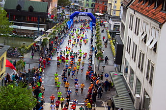 Aerial View of Marathon Runners Passing Under Blue Asics Arch in European City
