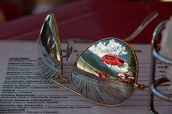 Sunglasses reflecting beach resort on restaurant menu