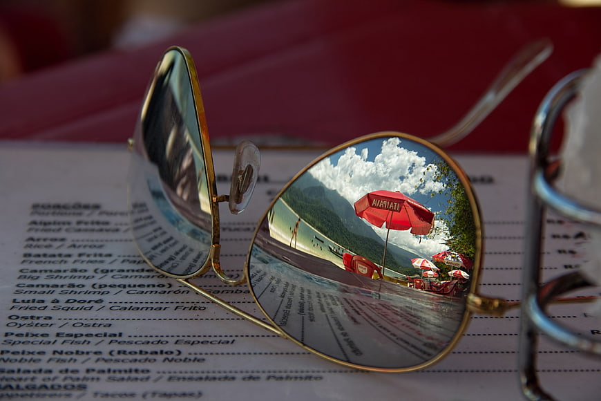 Sunglasses reflecting beach resort on restaurant menu