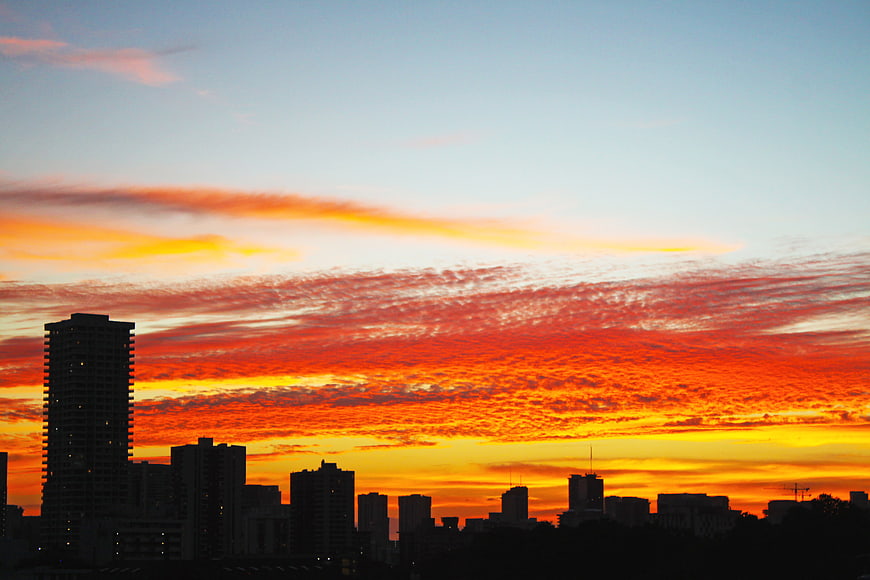 Vibrant orange sunset over city skyline silhouette