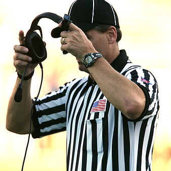Football Referee Adjusting Headset on Field