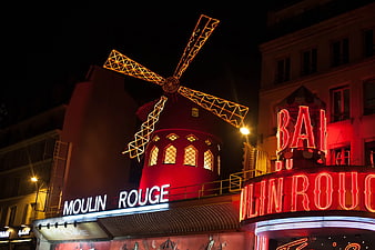 Moulin Rouge windmill and neon sign at night in Paris