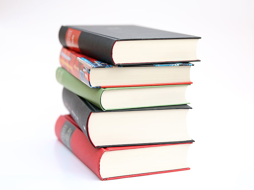 Stack of colorful hardcover books on white background