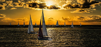 Sailboats on Golden Sunset Sea with Dramatic Clouds