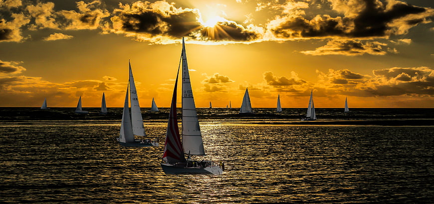 Sailboats on Golden Sunset Sea with Dramatic Clouds