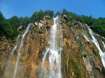 Majestic Waterfall Cascading Down Rocky Cliff in Plitvice Lakes National Park