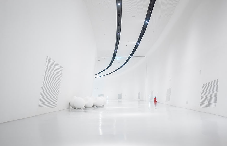 Minimalist white interior with curved ceiling and modern lighting