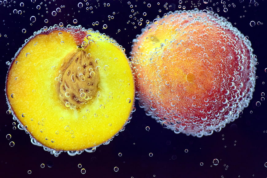Fresh Peaches Submerged in Sparkling Water with Bubbles