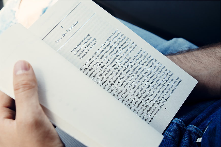 Close-up of man reading book with visible text