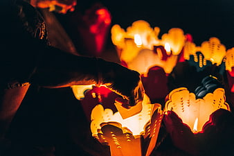 Hand Lighting Paper Lotus Lanterns at Night