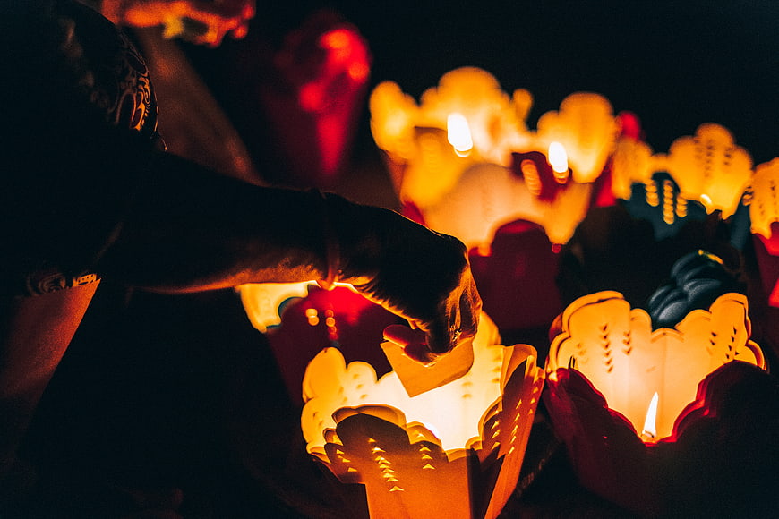 Hand Lighting Paper Lotus Lanterns at Night