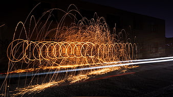 Steel wool spinning light painting with fire sparks at night