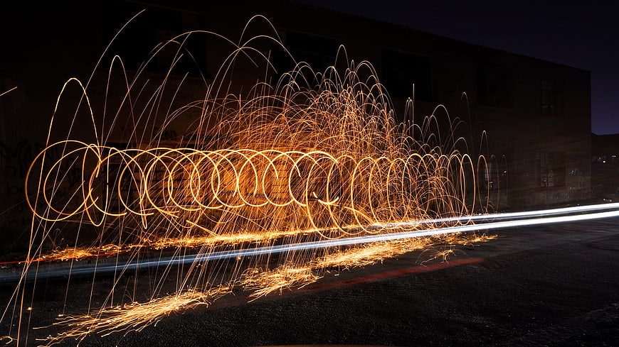 Steel wool spinning light painting with fire sparks at night