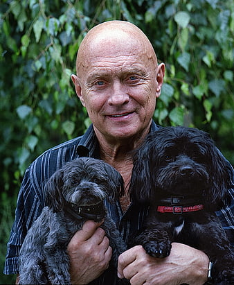Senior Man Holding Two Small Dogs Outdoors