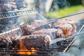 Sizzling Burgers Grilling on Outdoor BBQ with Smoke