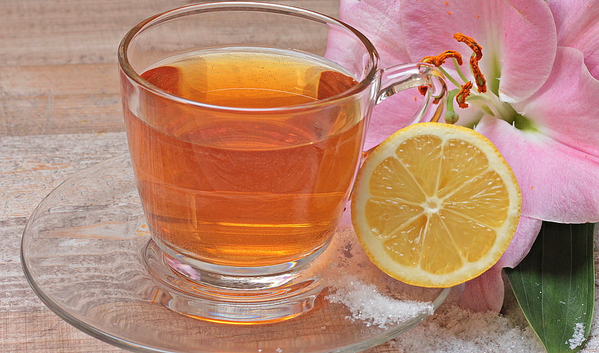 Glass Cup of Tea with Lemon Slice and Pink Lily Flower