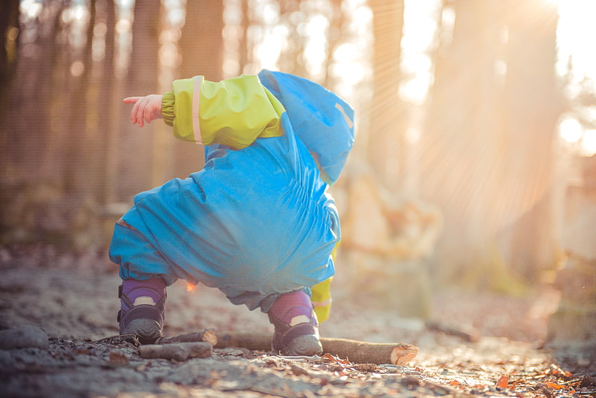 Toddler in Blue Raincoat Playing in Autumn Forest