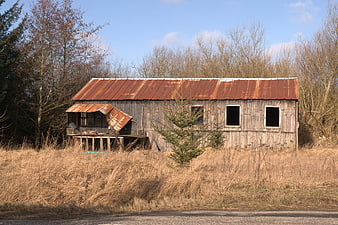 Abandoned Rustic Barn with Corrugated Metal Roof in Field
