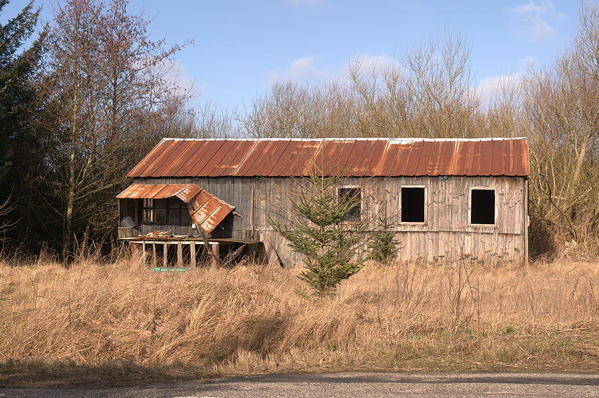 Abandoned Rustic Barn with Corrugated Metal Roof in Field