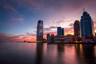 Dramatic City Skyline at Sunset Over Water