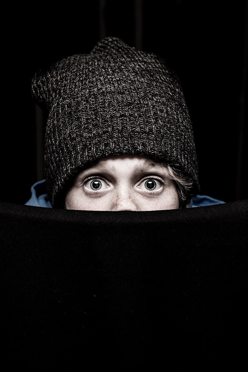 Playful Portrait of Woman Peeking Over Black Barrier