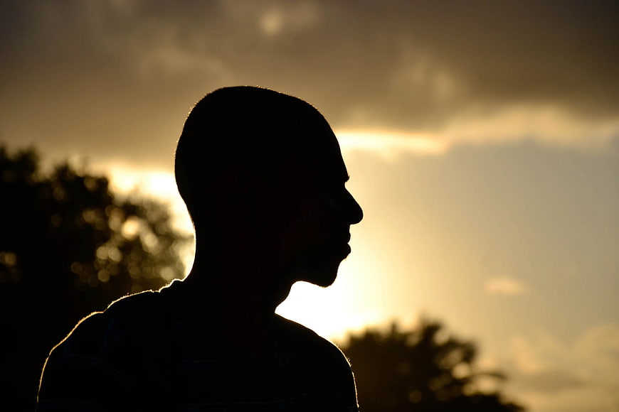 Silhouette of Man Profile Against Golden Sunset Sky