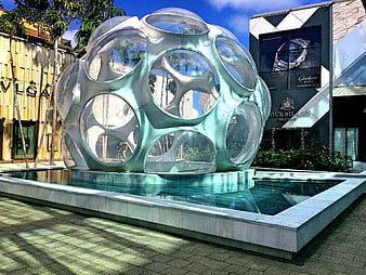Modern metallic sphere sculpture in luxury shopping plaza fountain