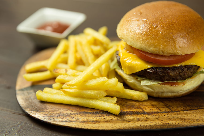 Cheeseburger with French Fries and Ketchup on Wooden Board