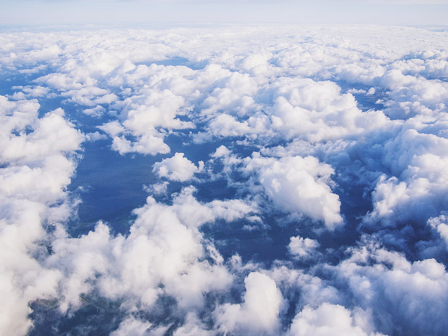 Aerial view of fluffy white clouds over blue ocean