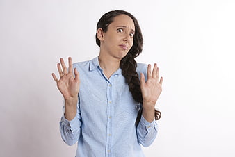 Shocked Woman with Hands Up Against White Background