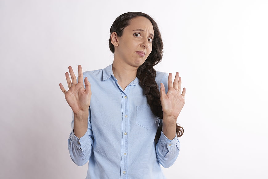 Shocked Woman with Hands Up Against White Background