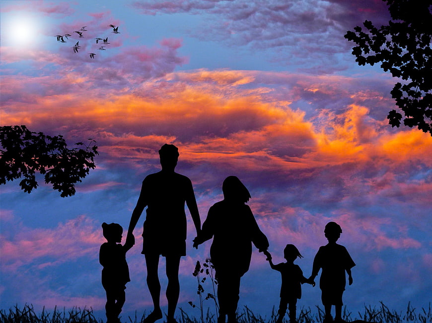 Silhouette of Family Holding Hands Against Colorful Sunset Sky