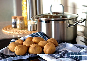 Fresh raw potatoes on kitchen towel with cooking pot