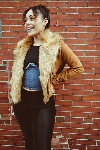 Happy Woman Laughing in Front of Red Brick Wall