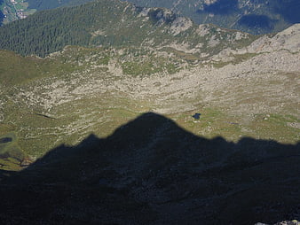 Mountain shadow cast over alpine valley landscape