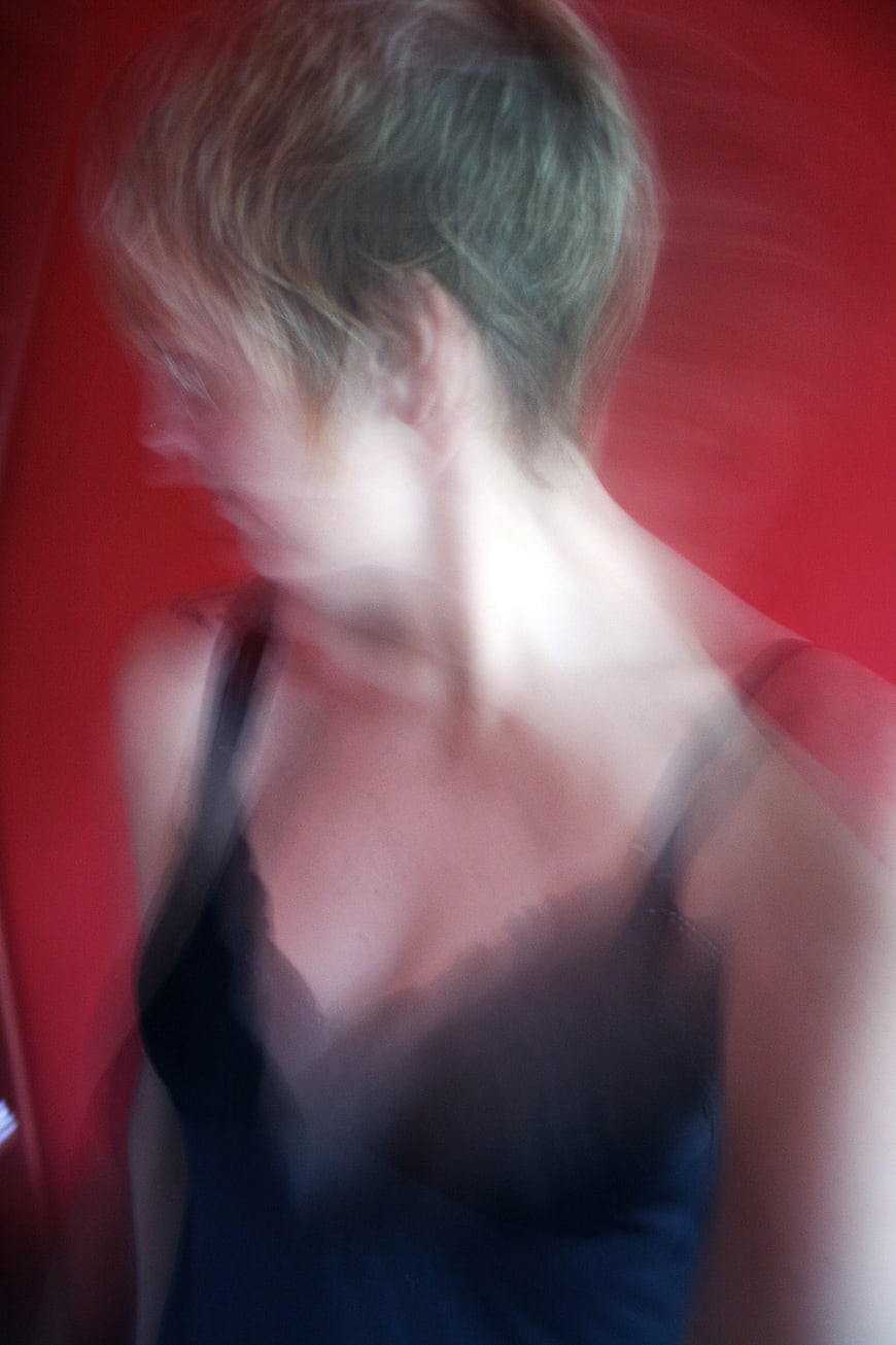 Blurred motion portrait of woman against red background