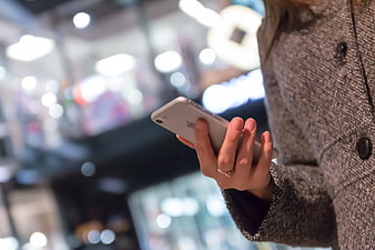 Close-up of Woman Using Smartphone in Shopping Mall
