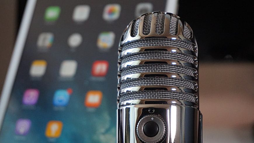 Vintage Chrome Microphone Close-Up With Blurred Tablet Background