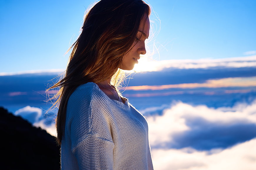 Woman in White Sweater Silhouette Against Clouds