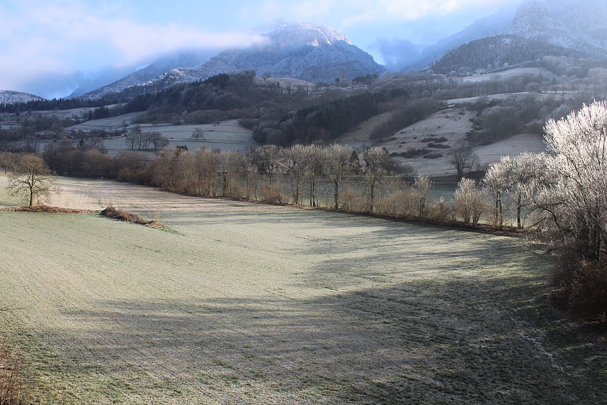 Frosty Winter Landscape with Snow-Capped Mountains and Frozen Lake